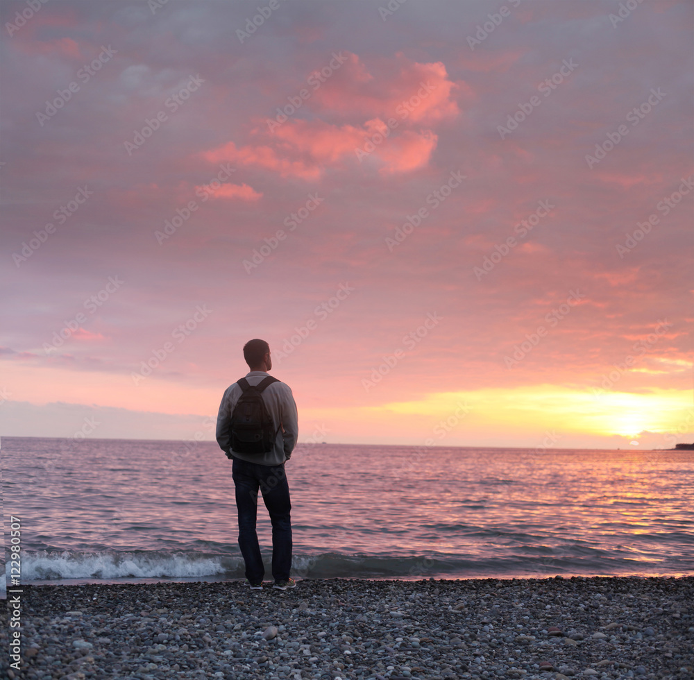 alone man looking at the sunset on a beach alone man looking at the sunset on a beach