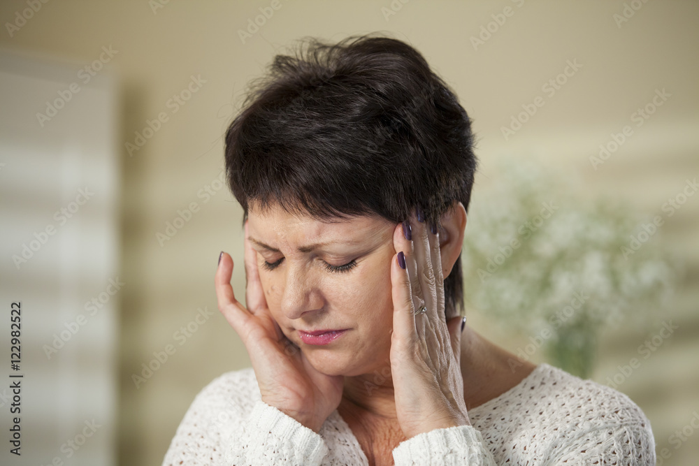 Attractive Mature woman having headache. Hands on temples. 
