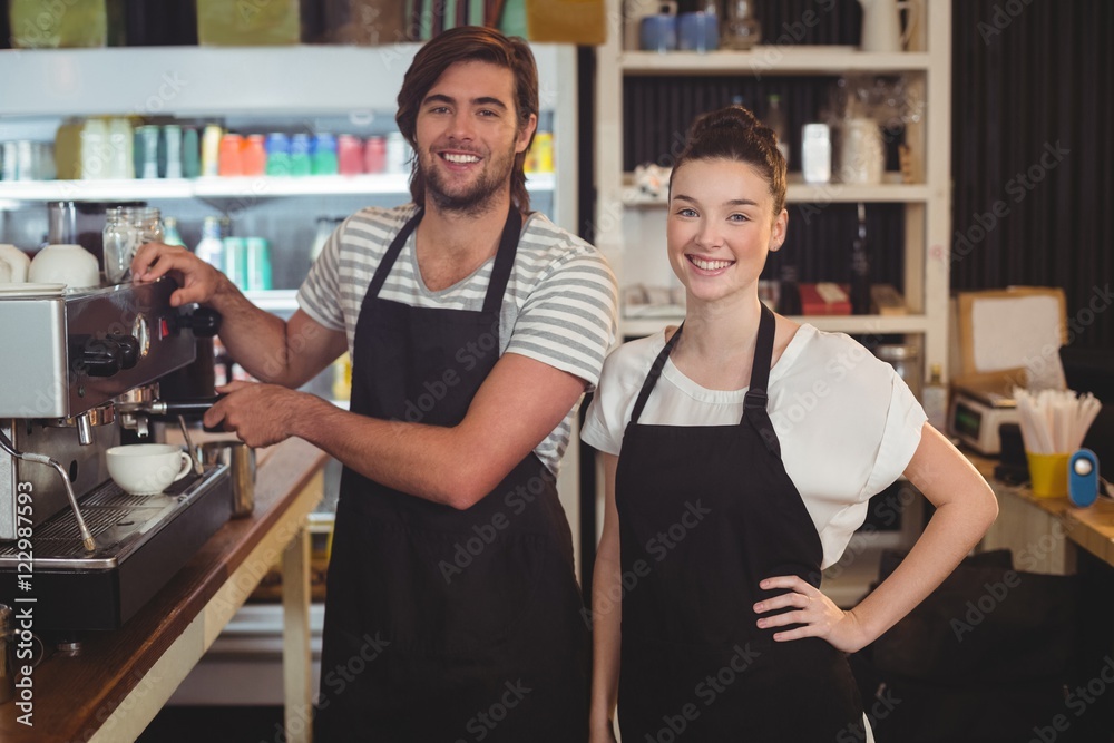 Portrait of waiter and waitress making cup of coffee at counter Portrait of waiter and waitress making cup of coffee at counter