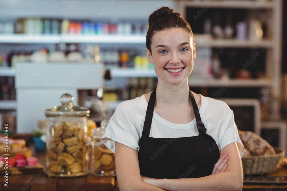 Portrait of smiling waitress standing with arms crossed Portrait of smiling waitress standing with arms crossed