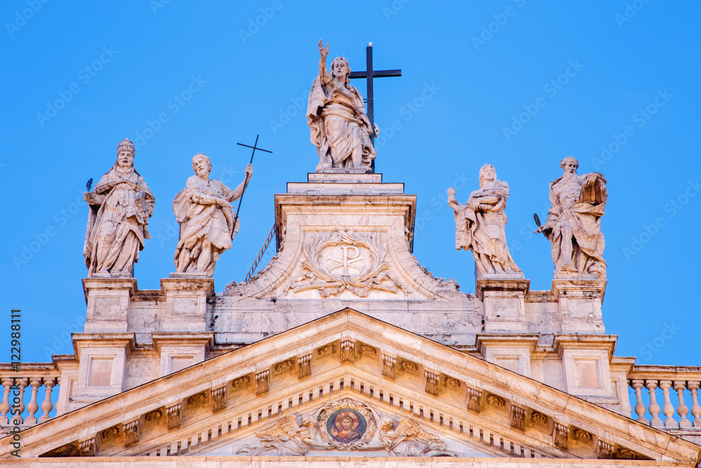 Rome - The statue on the top of facade of St. John Lateran basilica (Basilica di San Giovanni in Laterano) at dusk