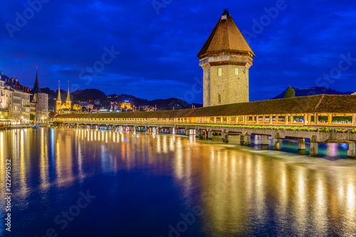Night view towards Chapel Bridge (Kapellbruecke) together with the octagonal tall tower (Wasserturm) it is one of the Lucerne's most famous tourists attraction