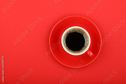 Americano coffee in full cup with saucer on red