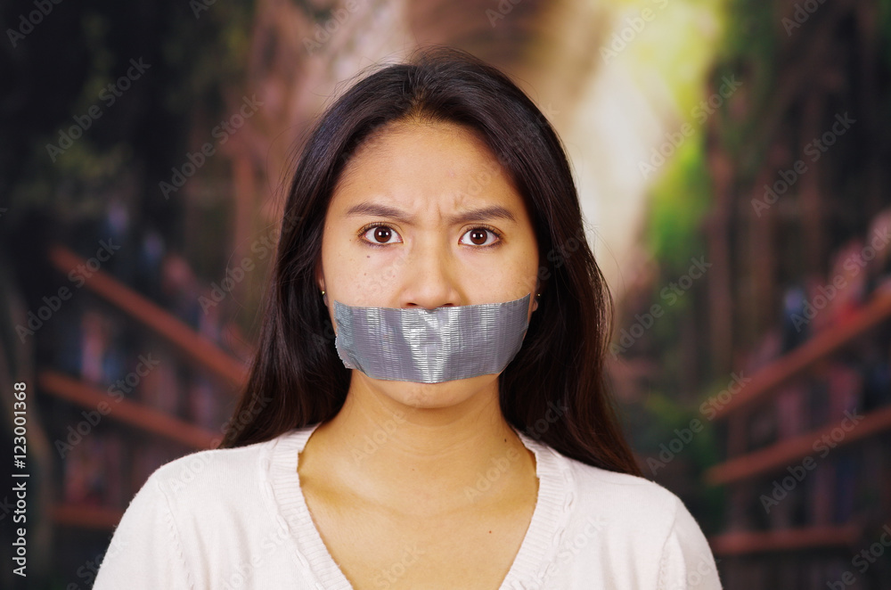 Young brunette woman wearing white sweater with and duct tape covering  mouth, facing camera, hostage concept Stock Photo | Adobe Stock