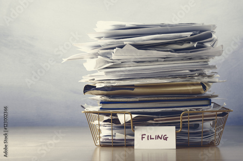 Filing Tray Piled High with Documents in Drab Hues photo