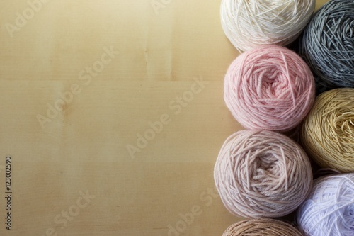 Balls of wool cotton silk yarn set on copy space wood background on left