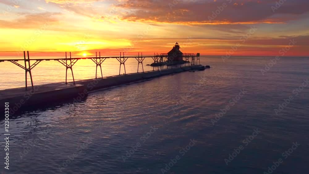 Amazing sunrise with Lake Michigan lighthouse, moving aerial perspective.
Amazing sunrise with Lake Michigan lighthouse, moving aerial perspective.