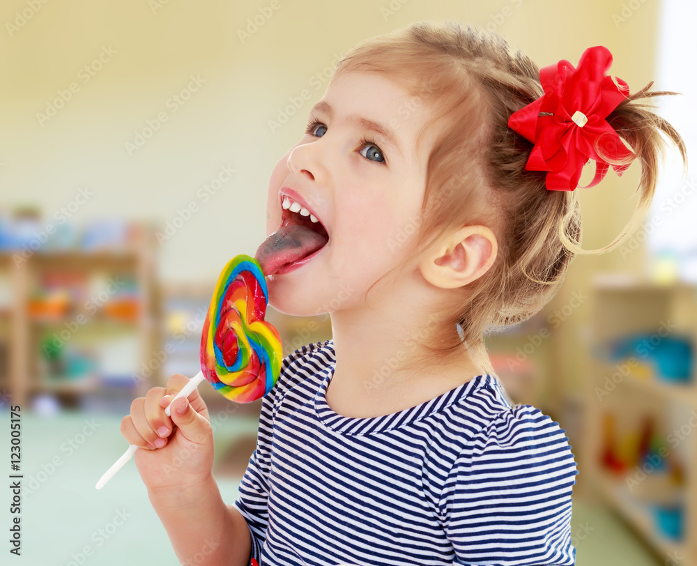 Girl licks candy on a stick