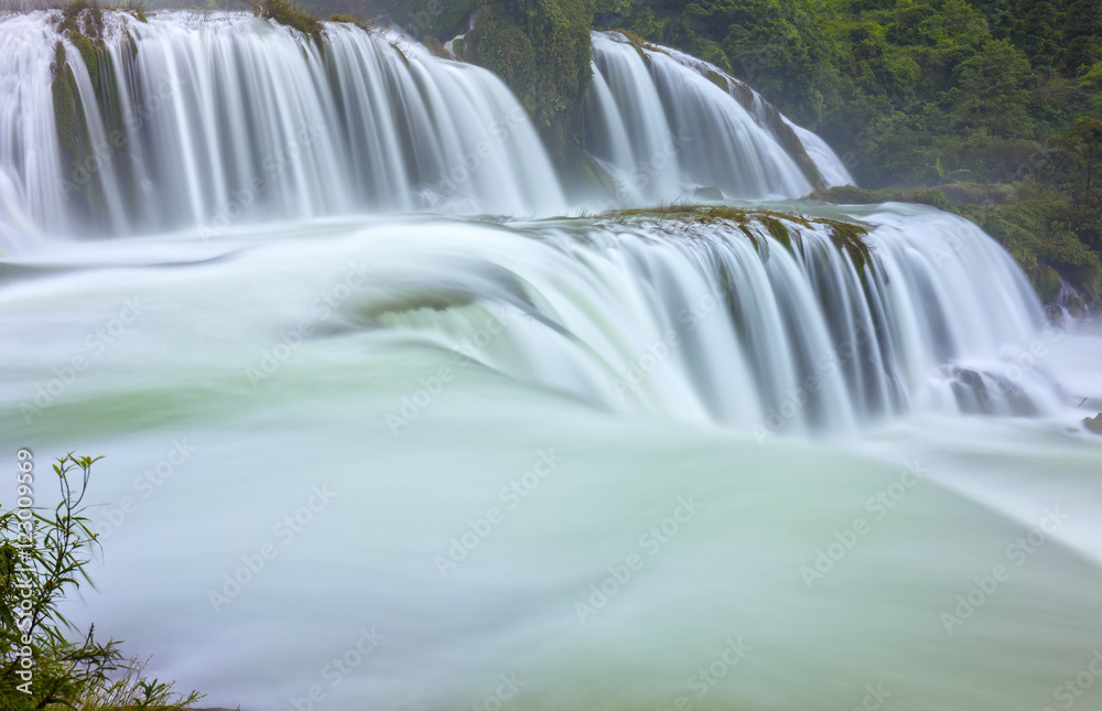 Fototapeta premium Ban Gioc Waterfall shimmering silk sheet honoring scenic beauty of Vietnam most beautiful waterfalls. It is rugged border region had known as tourist attraction