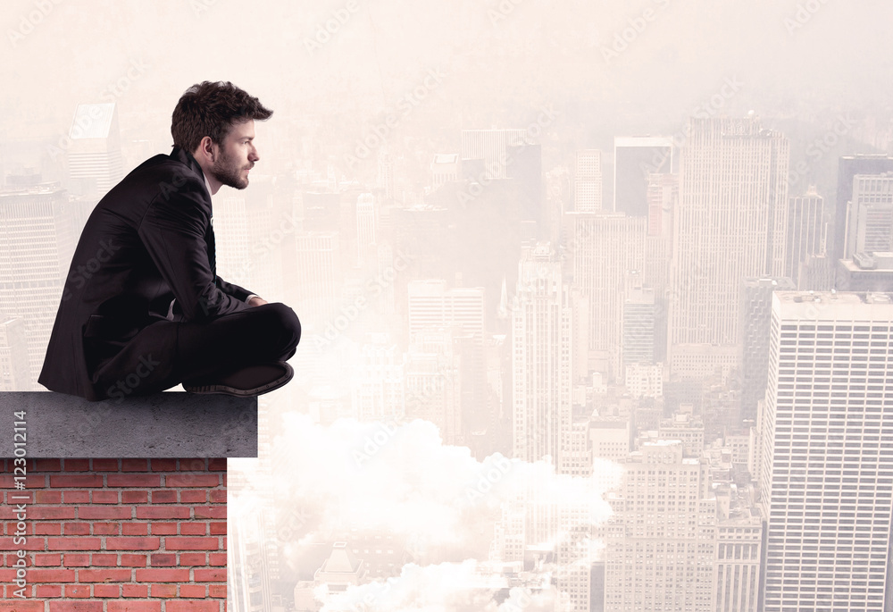 Office worker sitting on rooftop in city Office worker sitting on rooftop in city