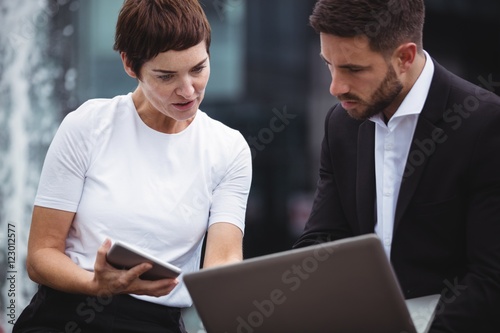 Businesspeople discussing over laptop