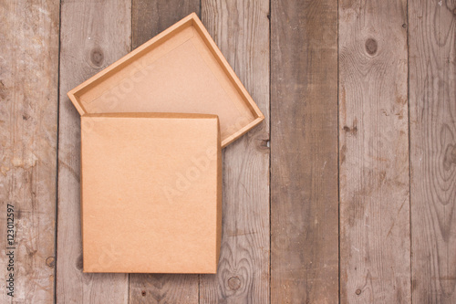 Opened cardboard box on wooden background