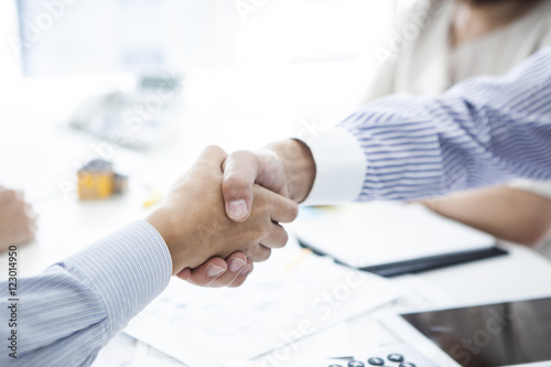 Businessmen and customers who are shaking hands in the company