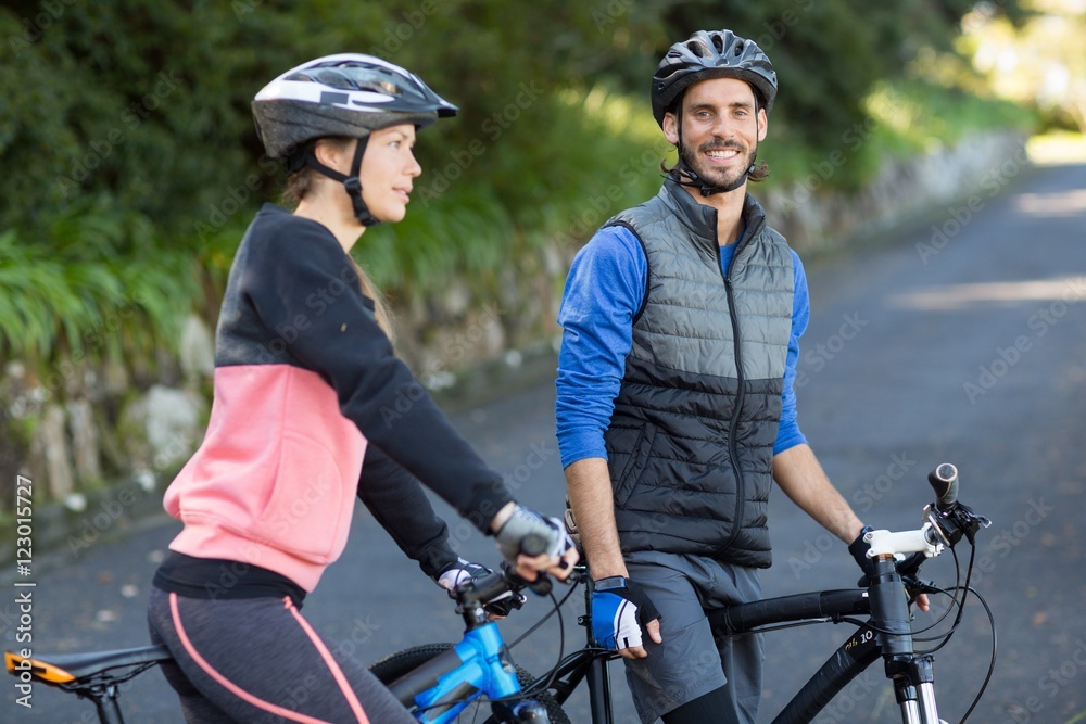 Biker couple with mountain bike on the road Biker couple with mountain bike on the road