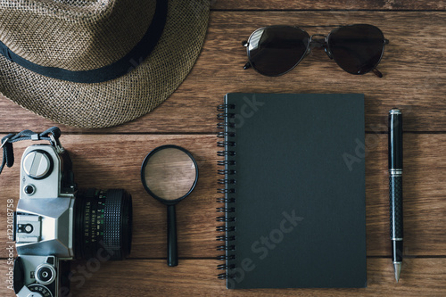Black notebook with copyspace and retro camera on wooden backgrond