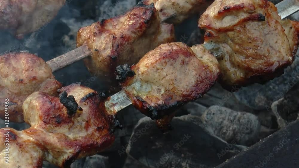 Preparation of a shish kebab. Skewers strung with them slightly burnt meat smoke on the coals. Close-up. Preparation of a shish kebab. Skewers strung with them slightly burnt meat smoke on the coals. Close-up.