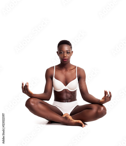 Gorgeous african girl portrait sitting cross-legged while meditating