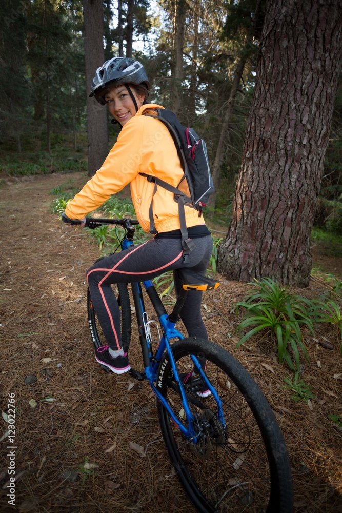 Female biker with mountain bike in countryside