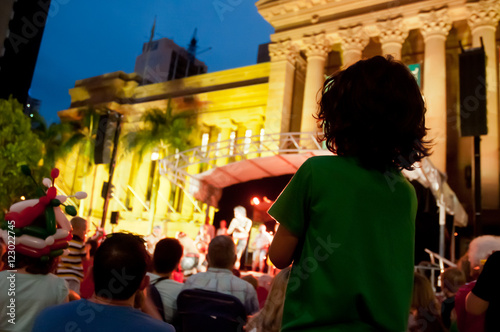 Kid stands to enjoy concert at night