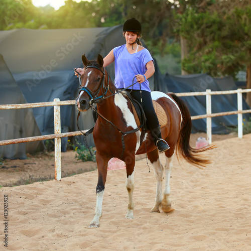 A Young girl getting a horseback riding lesson