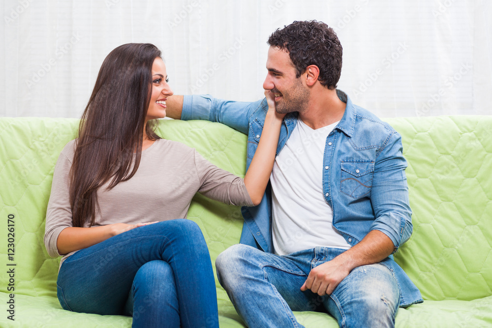 Happy couple sitting on sofa at their home. Happy couple sitting on sofa at their home.