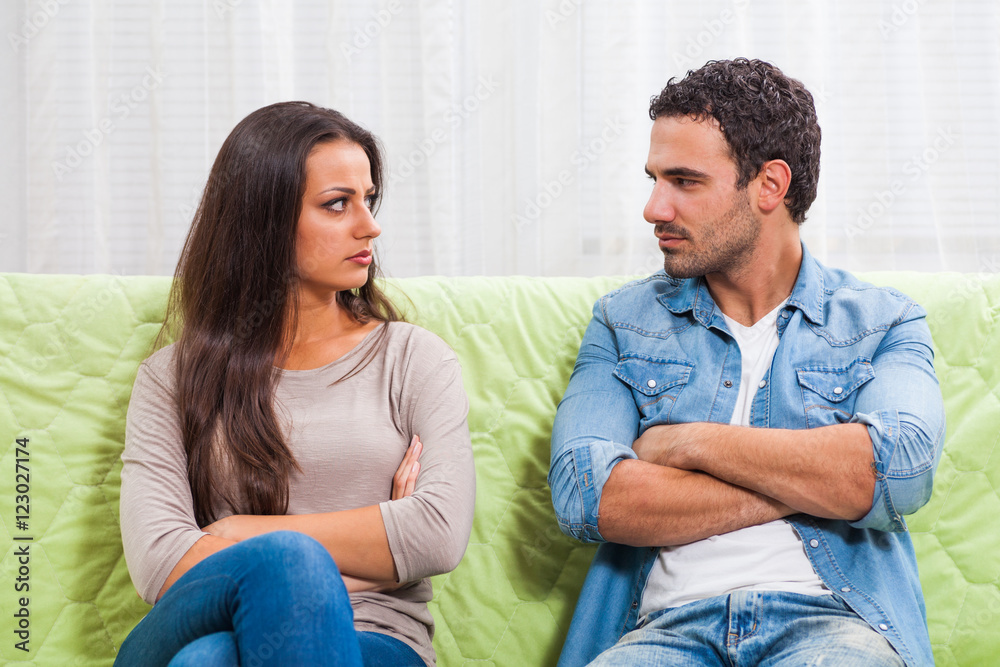 Young couple is sitting on sofa at home. They are angry and not talking to each other. Young couple is sitting on sofa at home. They are angry and not talking to each other.