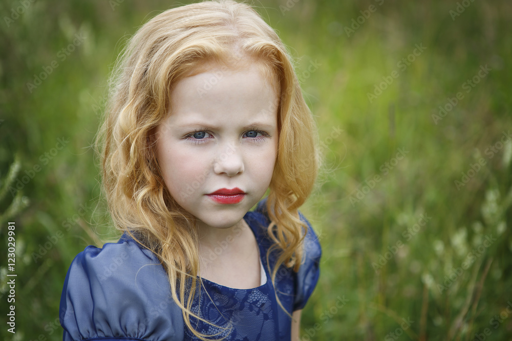 Portrait of beautiful little girl in the blue dress on the nature Portrait of beautiful little girl in the blue dress on the nature