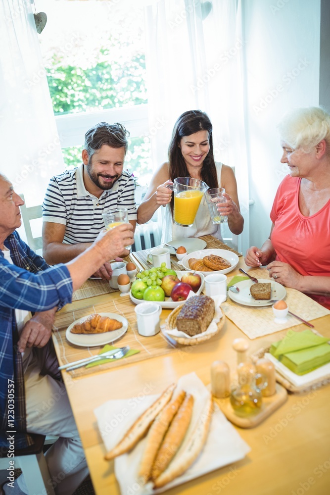 Happy couple having breakfast with their parents Happy couple having breakfast with their parents
