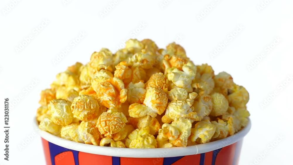 Cheese popcorn rotates on a white background. Close up shot Cheese popcorn rotates on a white background. Close up shot