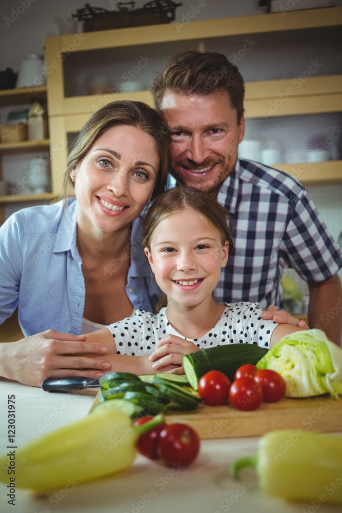 Portrait of happy family leaning on kitchen worktop
