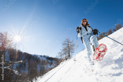 femme qui marche dans la neige avec des raquettes
