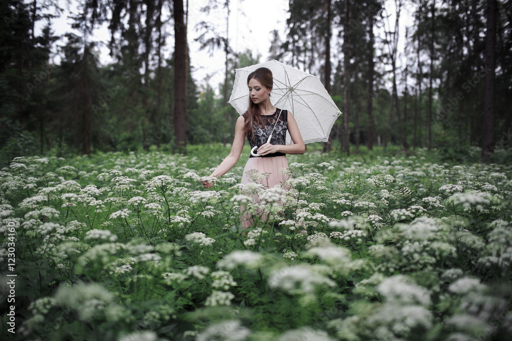 Portrait of beautiful girl with umbrella in nature and white flowers Portrait of beautiful girl with umbrella in nature and white flowers