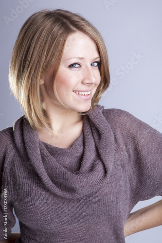 Portrait of a beautiful girl in a gray t-shirt with emotions in the Studio