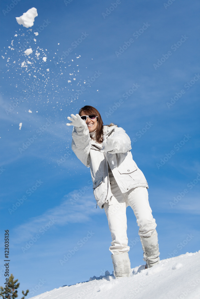 femme dans la neige qui rit en jetant des boules de neige femme dans la neige qui rit en jetant des boules de neige