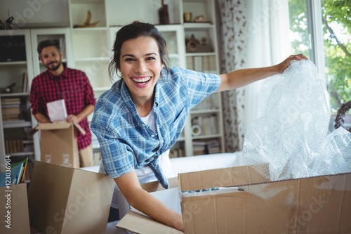 Happy couple unpacking cartons together photo