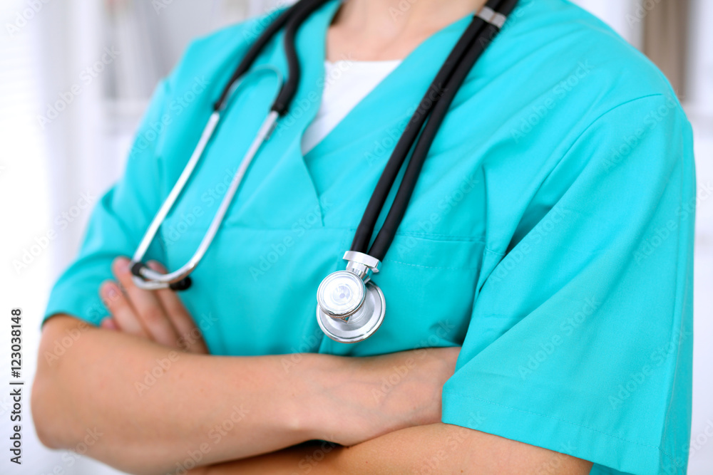 Female surgeon doctor is standing with arms crossed at hospital. Physician is ready to examine patient Female surgeon doctor is standing with arms crossed at hospital. Physician is ready to examine patient