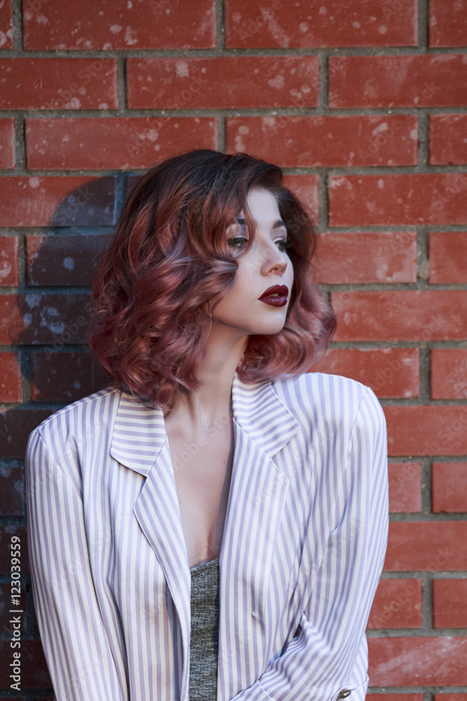 Portrait of a beautiful young girl in costume with the tattoo on the background of red brick wall Portrait of a beautiful young girl in costume with the tattoo on the background of red brick wall