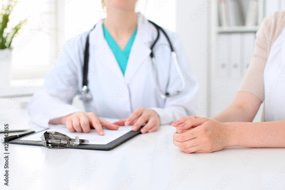 Doctor and patient are discussing something, just hands at the table Doctor and patient are discussing something, just hands at the table