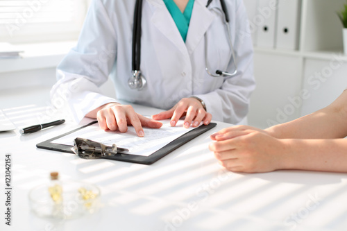 Doctor and patient are discussing something  just hands at the table