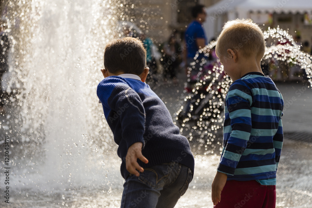 Bambini che giocano con fontana d'acqua Bambini che giocano con fontana d'acqua