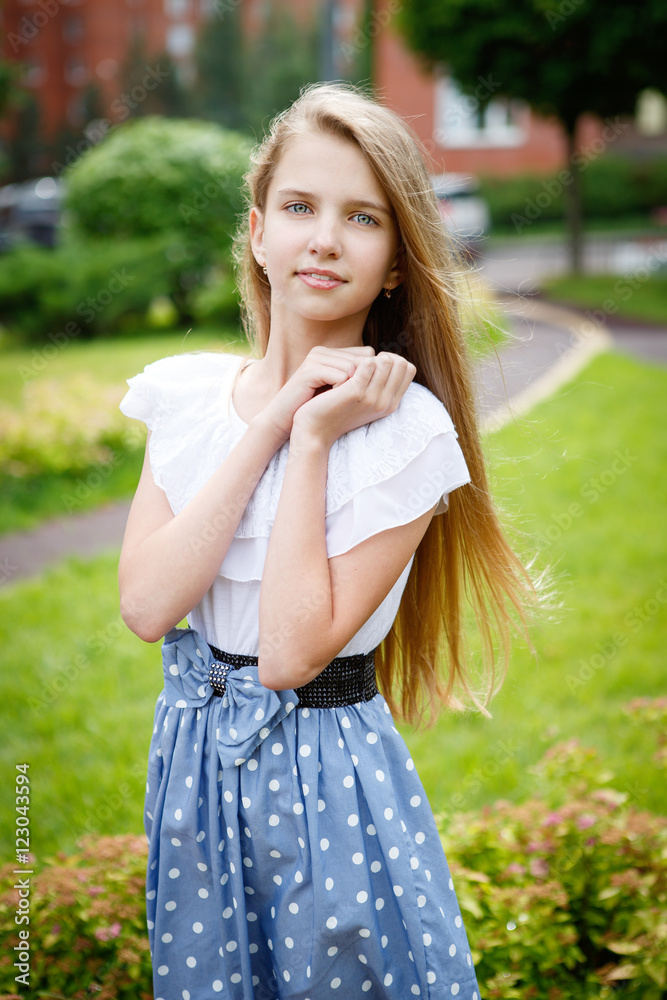 Portrait of a beautiful young girl in the Park skirt blouse nature fashion style