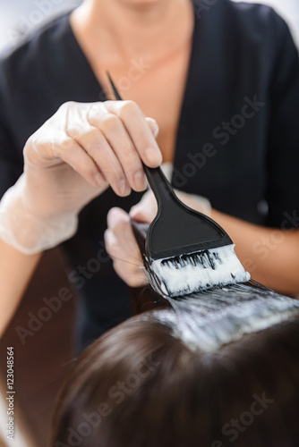 female stylist coloring customer hair