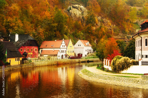 Cesky Krumlov - a famous czech historical beautiful town, view to the city river and beautiful autumn street with colorful buildings and fall trees. Travel european background