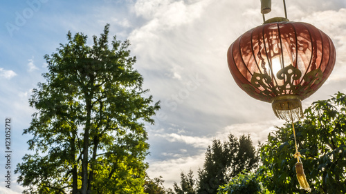 Red chinese lampion with golden ornaments illuminated by the sun photo