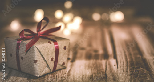Kleines Weihnachtsgeschenk mit Lichtpunkten vor Holz