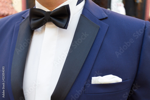 Close-up of grooms shirt blue jacket bow tie photo