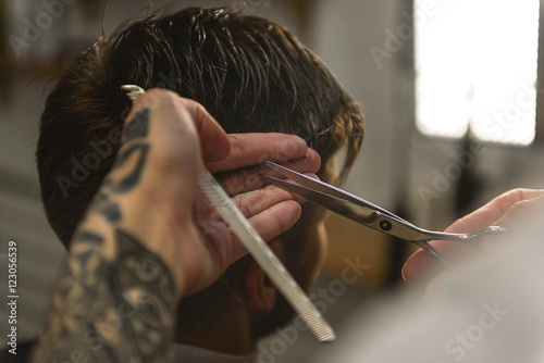 barber with equipment doing haircut