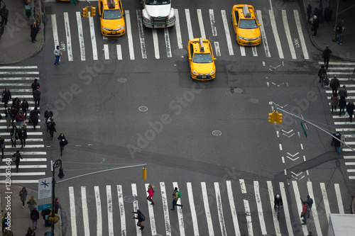 People walking in busy intersection with taxi 
