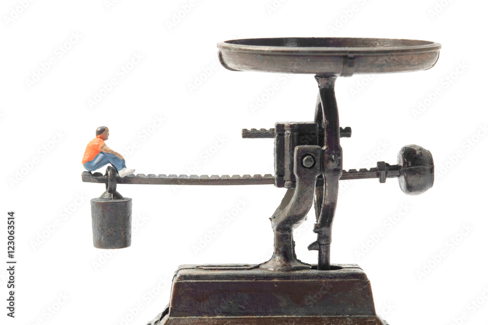 Toy people / View of miniature toy people sit on scales. Toy people / View of miniature toy people sit on scales.