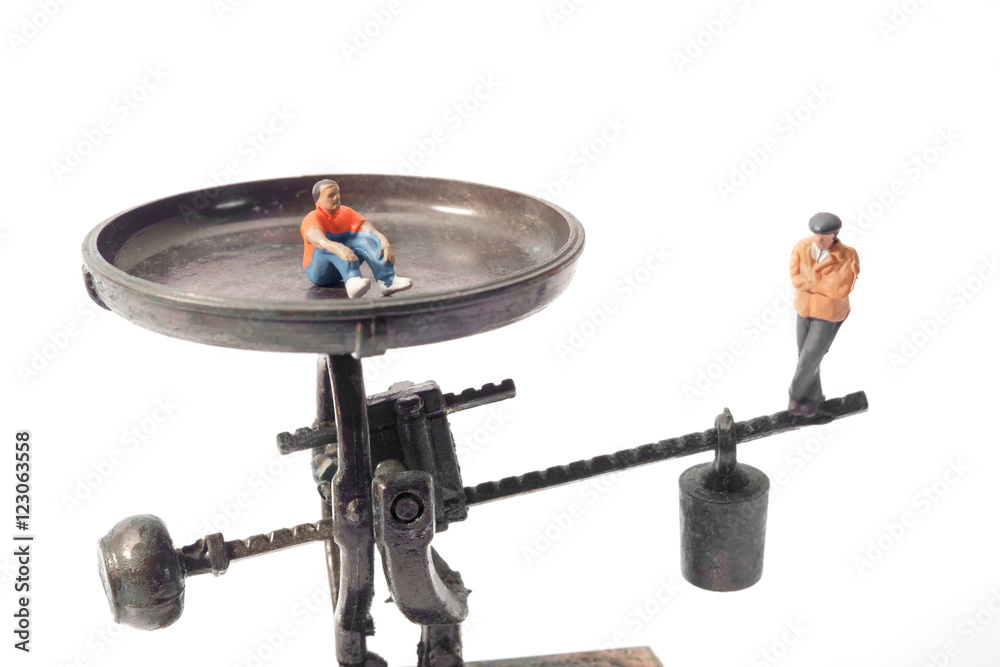 Toy people / View of miniature toy people sit on scales. Toy people / View of miniature toy people sit on scales.